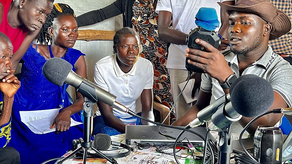 Placeholder: community radio recording session with microphones